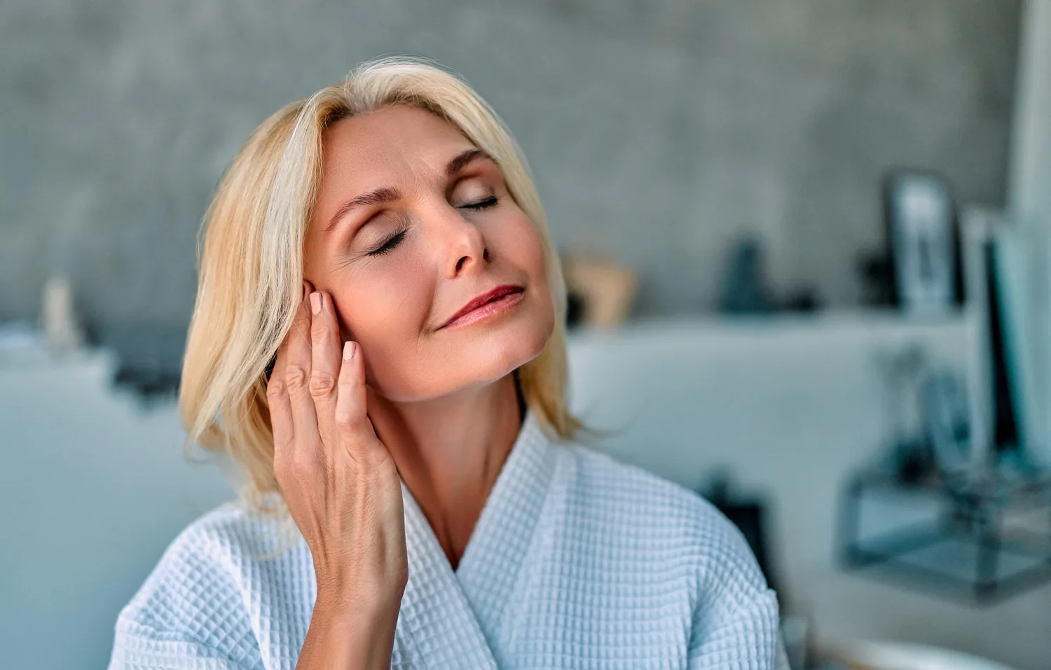 Femme sereine appliquant sa crème lors de son rituel de soin